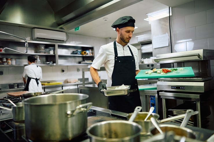 Professional cook working in restaurant kitchen.